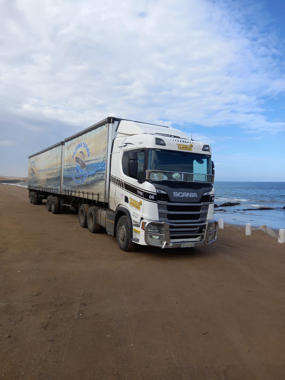 Topaz Atlantic Logistics Scania hauling branded curtain-side trailers along the Namibian coast